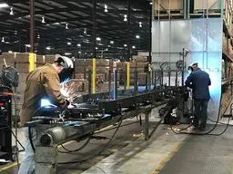 A group of men working on machinery in an industrial setting.