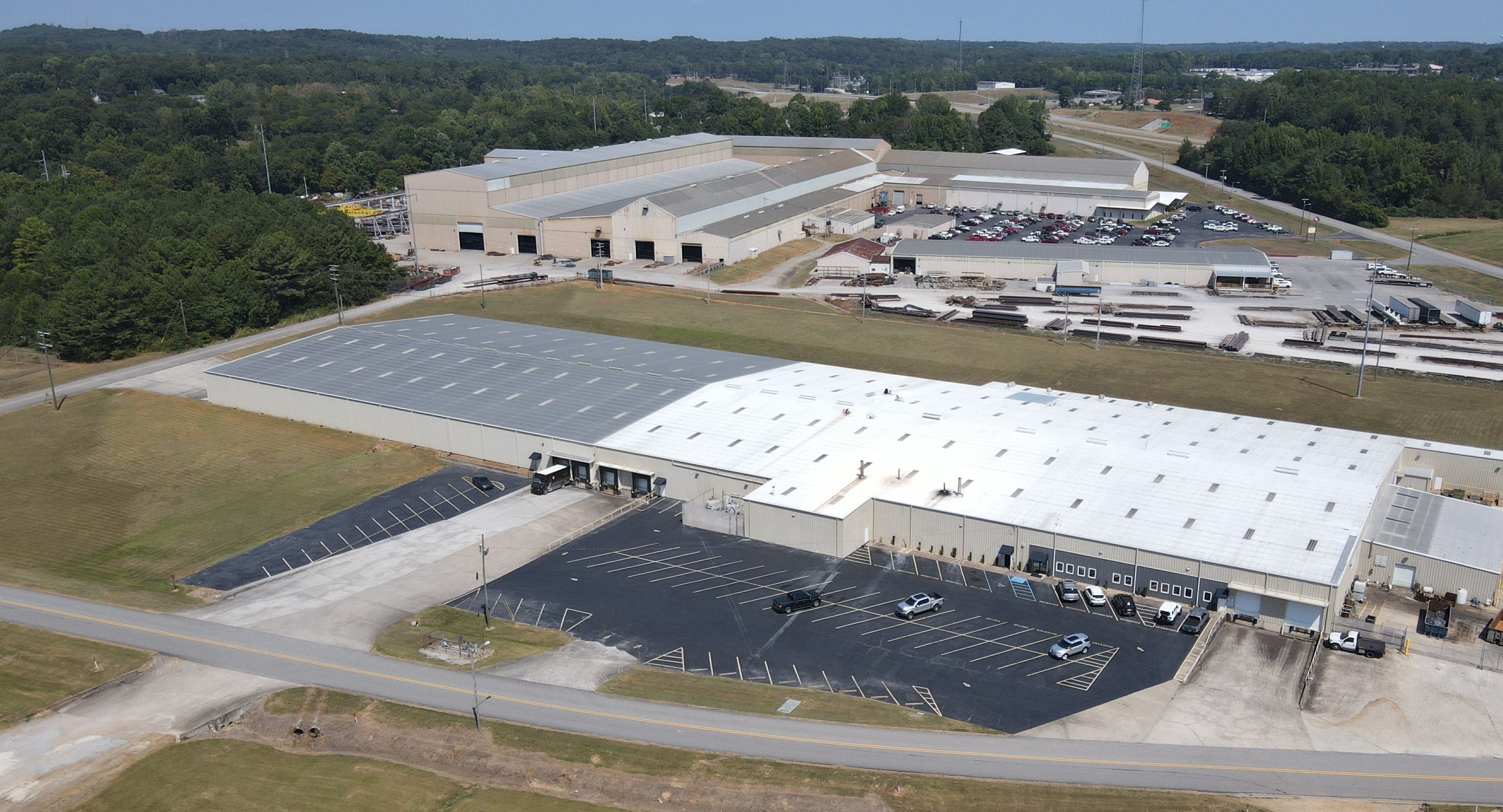 A large warehouse with many cars parked in it.