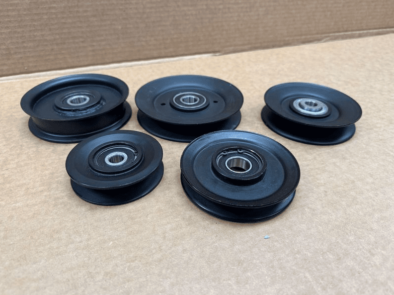 A group of five black wheels sitting on top of cardboard.