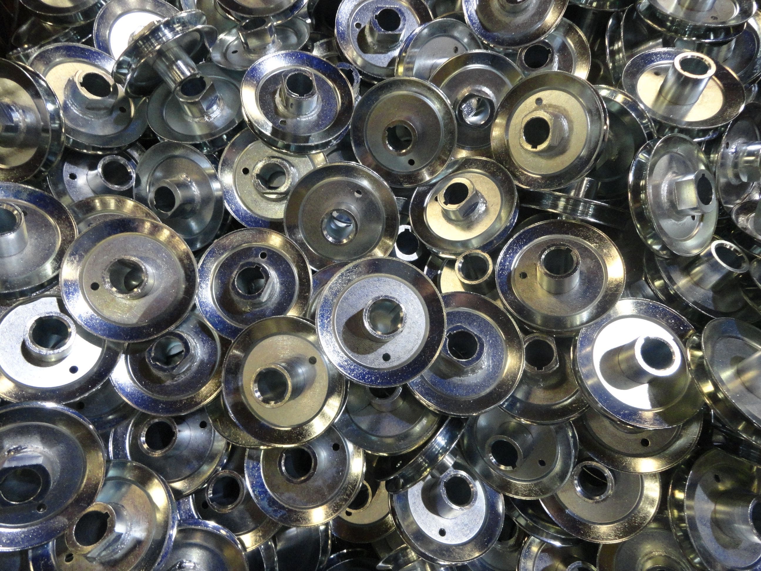 A pile of metal washers with holes in them.